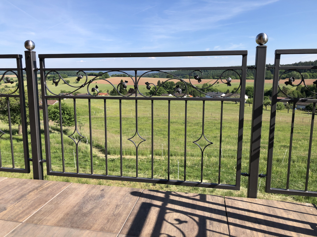 Schmuckvoll verziertes Außengeländer aus lackiertem Stahl von der Metallbaumanufaktur Berg aus dem Odenwald